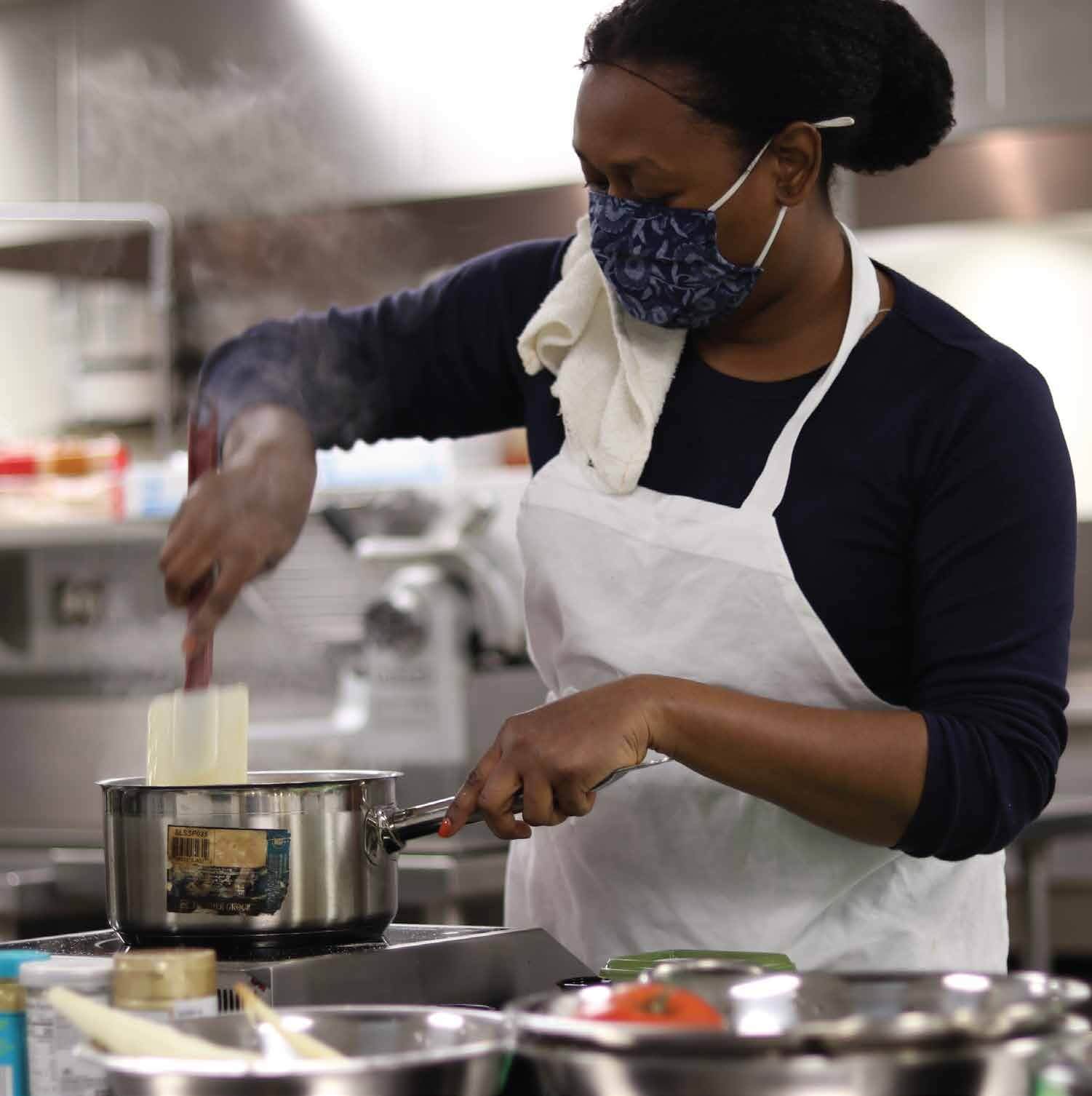 woman cooking in commercial kitchen